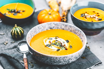 close-up view of pumpkin soup puree in bowls, corn and pumpkins on table