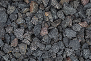 Close-up of dark gravel laying on the road