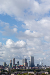 Vertical downtown cityscape of the modern city of Rotterdam with high rise buildings against a dramatic cloud filled blue sky