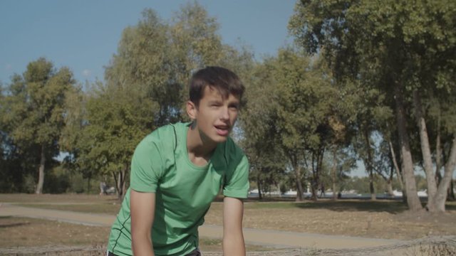 Portrait of handsome soccer player taking correct throw-in from touchline, returning ball to play during football match. Footballer holding ball and doing throw-in while playing soccer on sports field