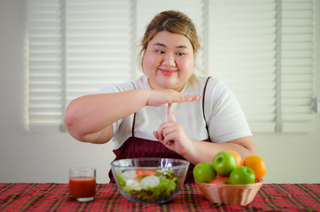 plump fatty woman anti and refused to eat salad vegetable and fruit on table, do not wants to eat salad food, against vegetable green salad, un-preferable fruit vegetable salad