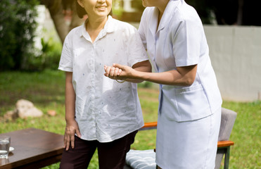 Nurse holding hands to elderly Asian woman with Alzheimer disease,Positive thinking,Happy and smiling,Take care and support concept