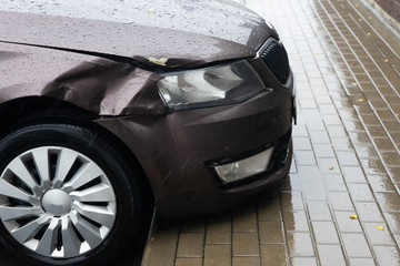 The body of the car in an accident. Crumpled wing. Cloudy autumn rain.