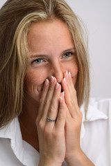 portrait of a young beautiful girl in a white shirt and jeans on a gray background
