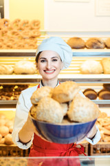 Verkäuferin in der Bäckerei bietet frisches Gebäck an