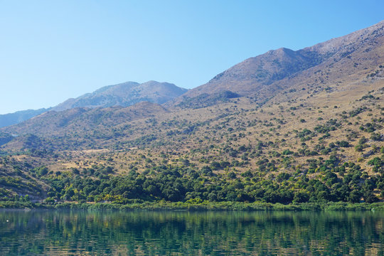Reflection of mountains in the blue water of Lake Kournas