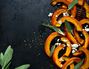Baked pumpkin slices with honey, sage and ricotta. Top view with copy space.