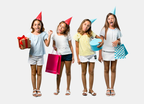 Set of Little girl at a birthday party holding a gift bag showing tongue at the camera having funny look on grey background