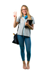 A full-length shot of Student girl with glasses happy and counting three with fingers on isolated white background
