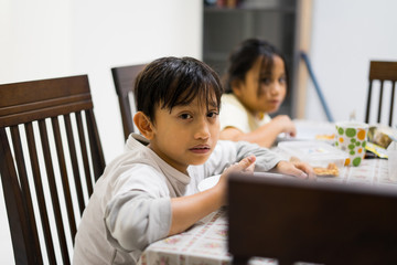 Obraz premium Asian kids eating food at home.