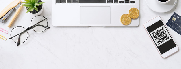 Online payment with QR code concept, virtual credit card, smart phone on office laptop desk on clean marble table background, top view, flat lay