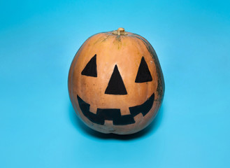 The Concept Of Halloween. Jack's scary and horrible lantern is drawn on a pumpkin on a light blue background.