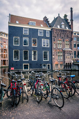 Fototapeta na wymiar Bicycles in Amsterdam street near canal with old houses