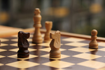 wooden chess pieces on a cage board, skyline intentionally curved close-up, copy space