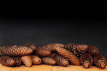 fir cones on a wooden table on a black background, concept christmas, new year, blank for the designer,, close-up, copy space