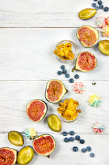 Fresh sliced figs with granola, blueberry, and plums as autumn food background. Flat lay