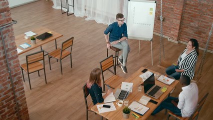 Top View of Startup Employees Team Working in Loft Office. Overhead Diverse Business Casual People Meeting for Project Discuss using Laptops and Flipchart. 4K High Angle Long Gimbal Background Shot