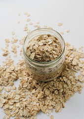 Scatterd raw oat-flakes on white background