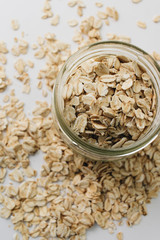 Scatterd raw oat-flakes on white background
