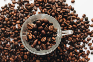 Close-up view of roasted coffee beans and glass cup