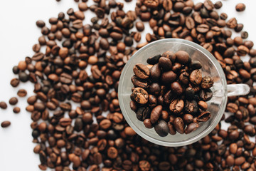 Close-up view of roasted coffee beans and glass cup