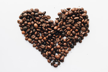 Close-up view of roasted coffee beans, pile in shape of heart