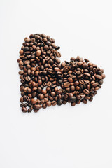Close-up view of roasted coffee beans, pile in shape of heart