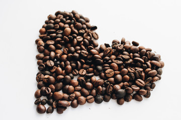Close-up view of roasted coffee beans, pile in shape of heart