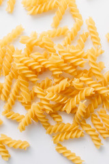 Pile of uncooked macaroni on white background