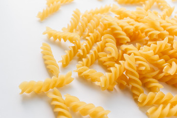 Pile of uncooked macaroni on white background