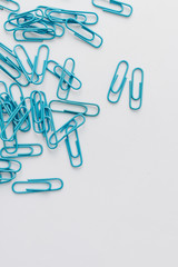 Pile of blue paper clips on blue background