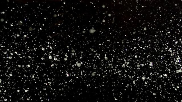 Strawberries with water droplets collide on black background closeup in super slow motion