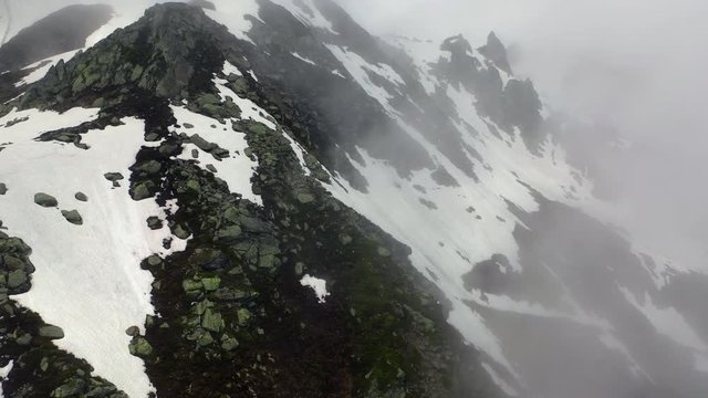 Aerial Tilt-up: Snowy Mountain Ridge with Amazing Cliffs in the Clouds - Le Brevent, France