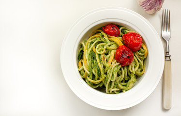 italian Pasta with zucchini noodles and Avocado Sauce and garlic in white plate. Top view. Healthy food concept.