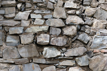 Wall from large stone texture basalt. Stone wall background. Large stones piled on top of one another.