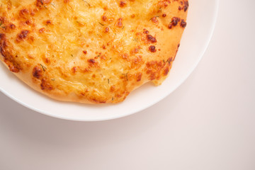 Fresh round cake on white plate on white background.