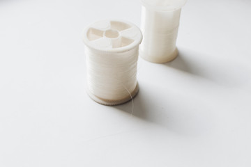 White sewing threads background closeup