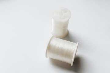 White sewing threads background closeup