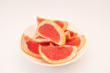Fototapeta na wymiar Fresh ripe juicy grapefruit on white plate on white background.