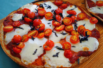 Pizza with fresh cherry tomatoes, mozzarella and opal basil on a cauliflower crust