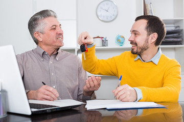 Mature man sign car purchase contract