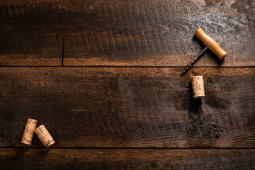 Corkscrew and wine corks on wooden table