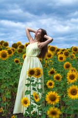 Portrait of a young beautiful girl in a field of sunflowers