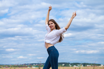 Young brunette woman in white shirt and blue jeans shorts