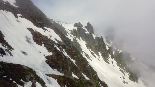 Aerial Forward: Snowy Mountain Ridge with Amazing Cliffs in the Clouds - Le Brevent, France