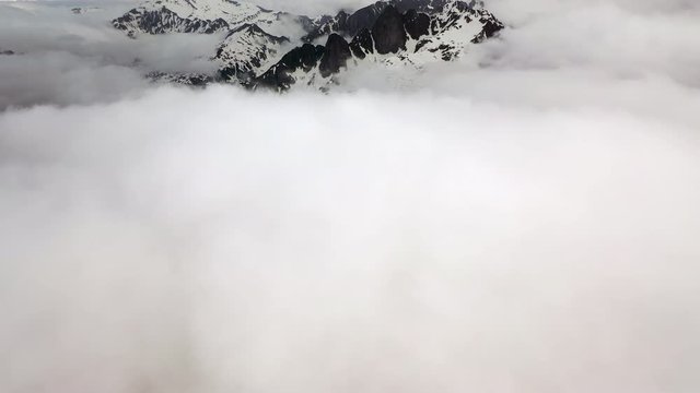 Aerial Tilt-up: Amazing Snowy Mountain in Thick Clouds - Le Brevent, France