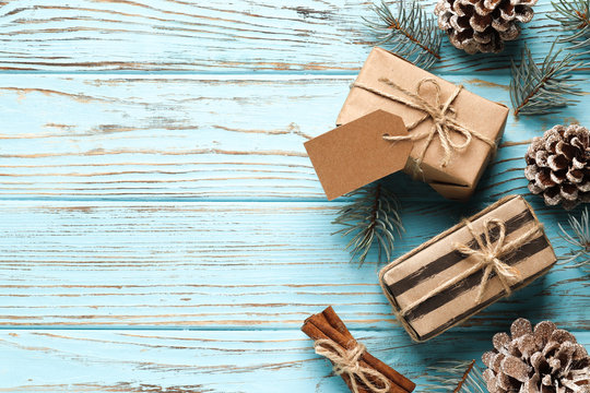 Flat lay composition of christmas gift boxes, cones, fir branches on a blue wooden background