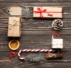 Flat lay Christmas Composition frame from red gift box, candy, fir branche, Dried orange fruits, tag on a brown wooden background.