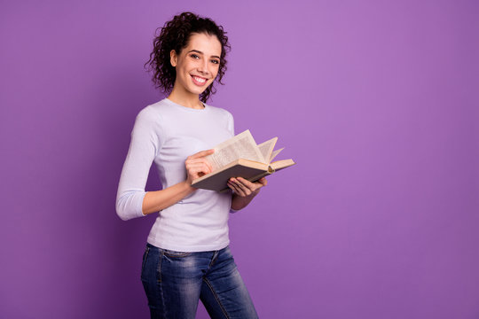 Photo of cheerful cute sweet nice charming girlfriend reading interesting book near empty space holding hands isolated over purple pastel color background