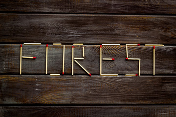 Fire concept with forest text on wooden background top view